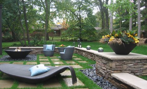 A backyard with stone walls and grass.