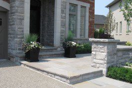 A house with stone steps and potted plants.