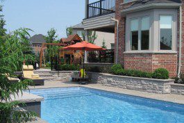 A swimming pool in the backyard of a house.