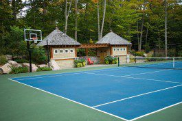 A blue tennis court with a gazebo in the background.