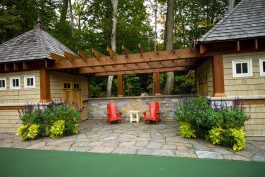 An outdoor patio with a pergola and red chairs.