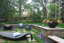 A backyard with a fire pit and lounge chairs.