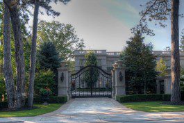 A gated entrance to a large mansion.