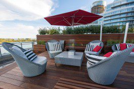 A deck with furniture and a red umbrella.