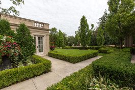 A garden with bushes and trees in the middle of it