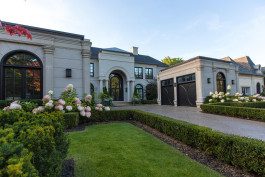 A large white house with a garden in front of it.