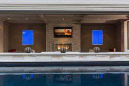 A living room with a fireplace and a swimming pool.