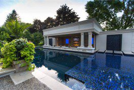 A swimming pool in a backyard with blue tiles.