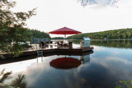 A dock with an umbrella and chairs on it