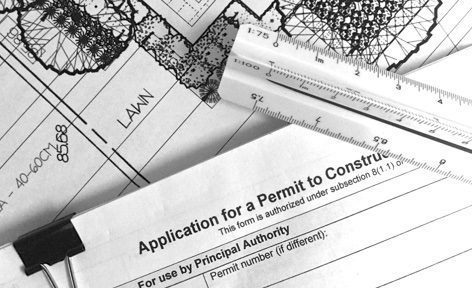 A construction permit sitting on top of some plans.