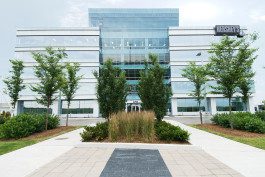 A building with trees and bushes in front of it.