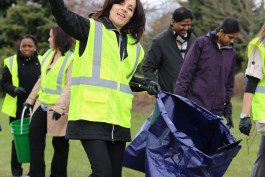 A woman in yellow vest holding up her hand.