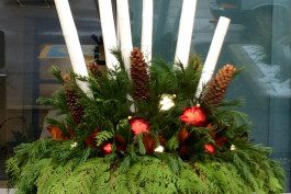 A table with candles and pine cones on it.