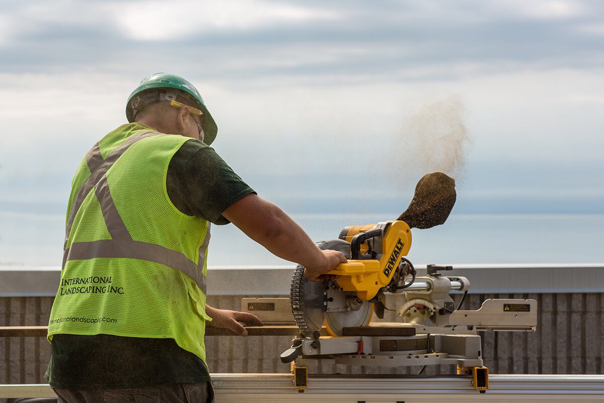 A construction worker is using a miter saw.