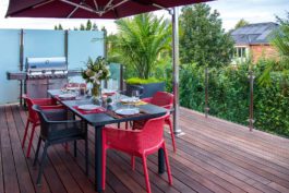 A table and chairs on top of a wooden deck.