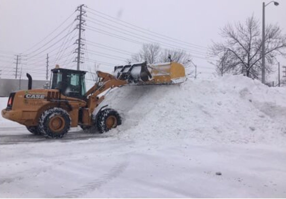 A white truck with a plow in the back.