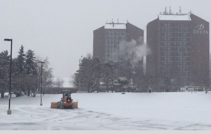 A white truck with a plow in the back.