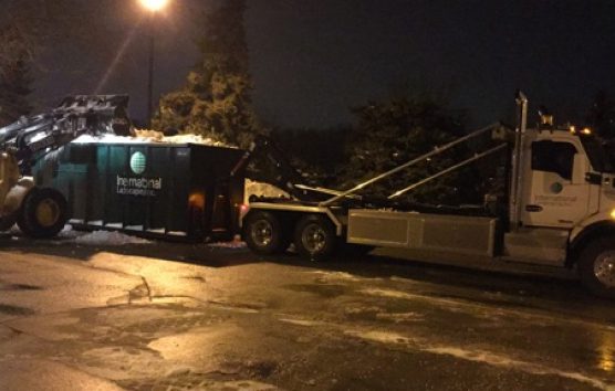 A white truck with a plow in the back.