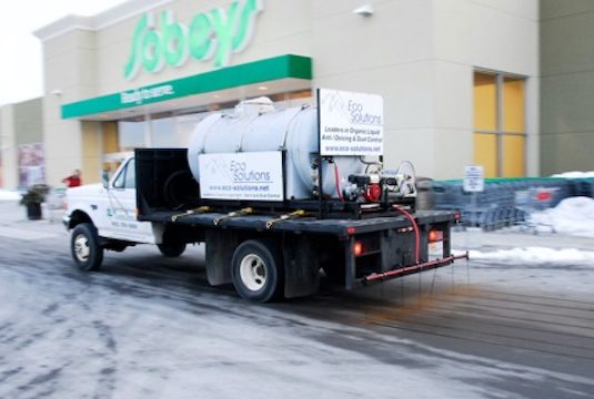 A white truck with a plow in the back.