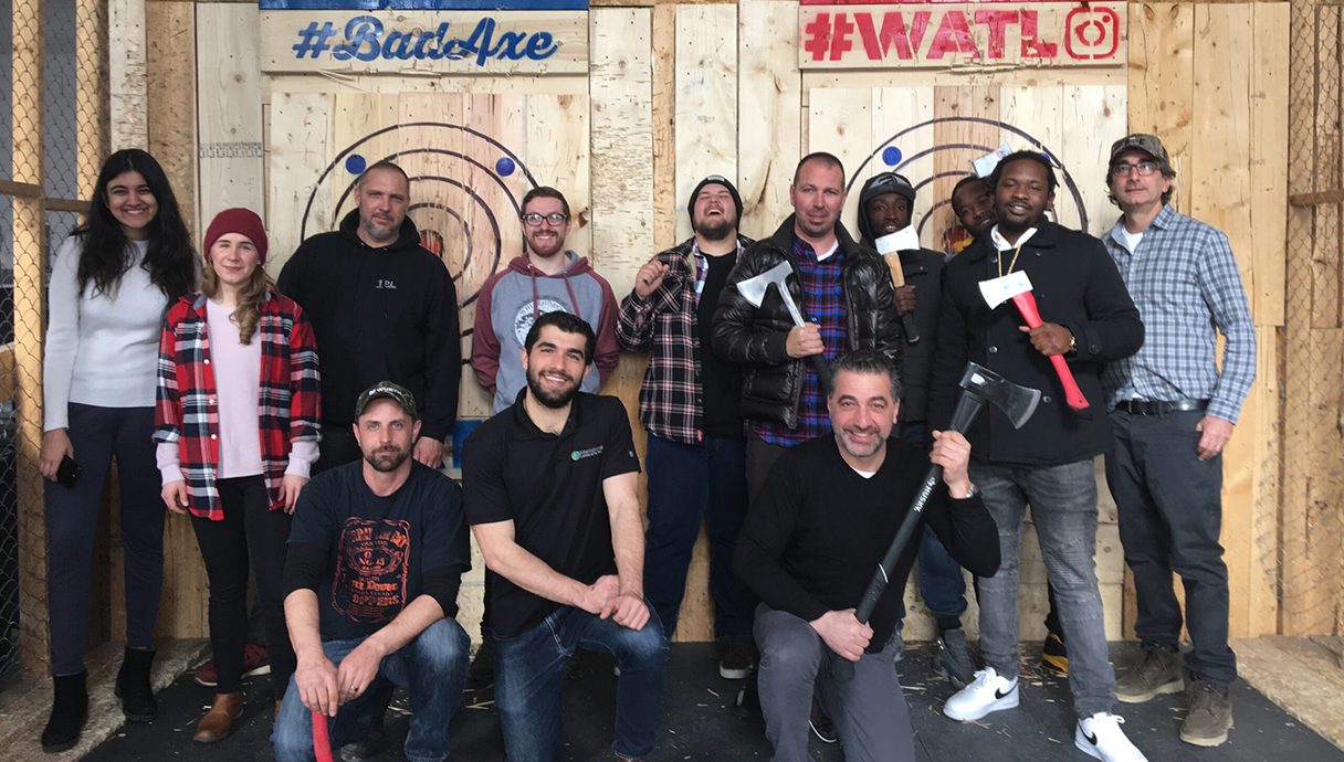 A group of people standing in front of a wall with arrows.