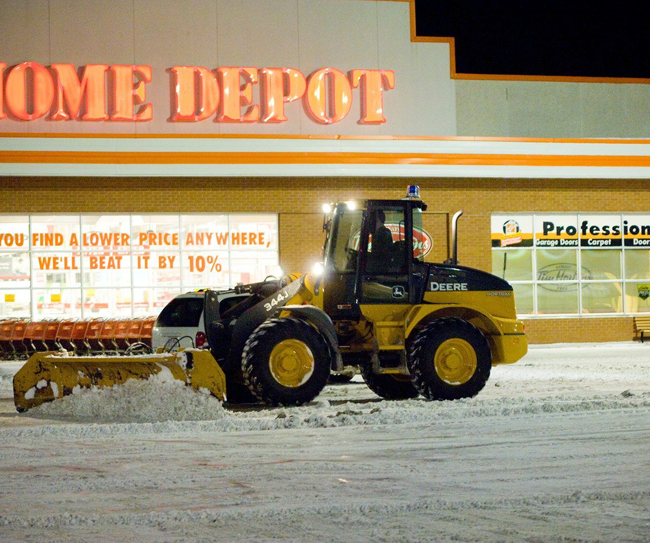 A white truck with a plow in the back.