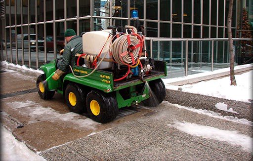 A white truck with a plow in the back.